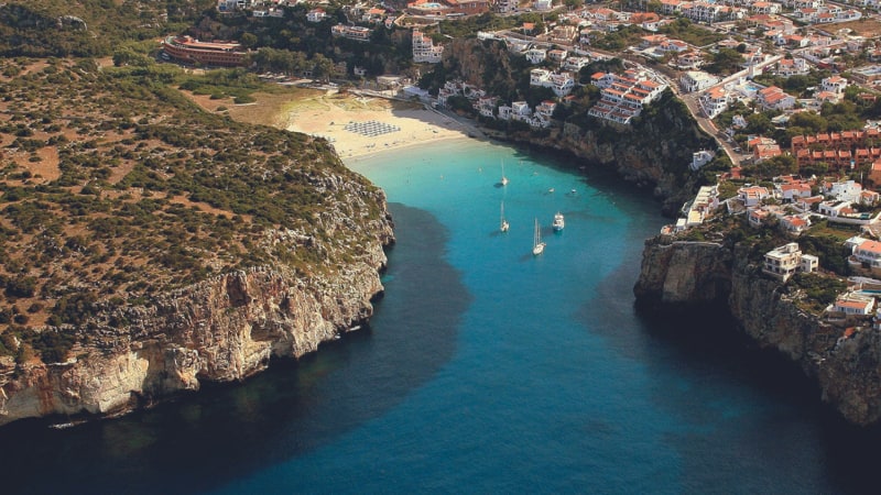 Birds flying over Cala Llucalari's natural landscape
